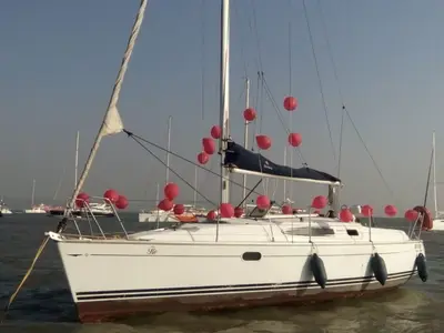 Flo decked out in red balloons at anchor, her nameplate visible on the bow
